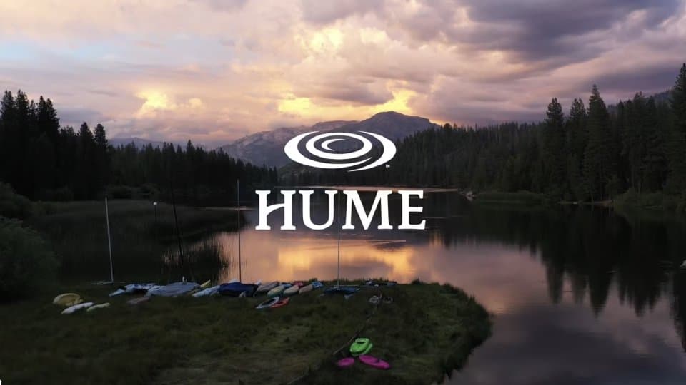 Hume Lake at sunset with kayaks on the shore and the Sierra Nevada behind